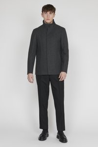 Grauer Wollmantel mit hohem Kragen, Einzelknopfverschluss und geradem Schnitt, kombiniert mit schwarzen Hosen und Lederschuhen. Minimalistisches Design.