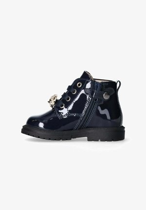 Stivaletto alla caviglia in vernice blu navy con suola nera in gomma, accentuato da dettagli metallici decorativi, lacci frontali e cerniera laterale per una facile calzata.