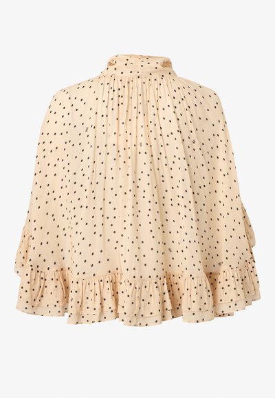 Μπεζ φούστα με μαύρες πουά, ψηλή σούρα στη μέση, ρέον ύφασμα και λεπτομέρειες βολάν στο τελείωμα.