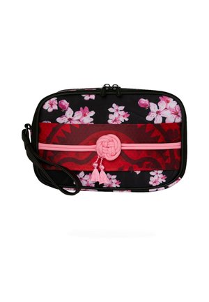 Muñequera negra rectangular con estampado floral en rosa y blanco, banda roja en el centro y nudo decorativo rosa con borlas.