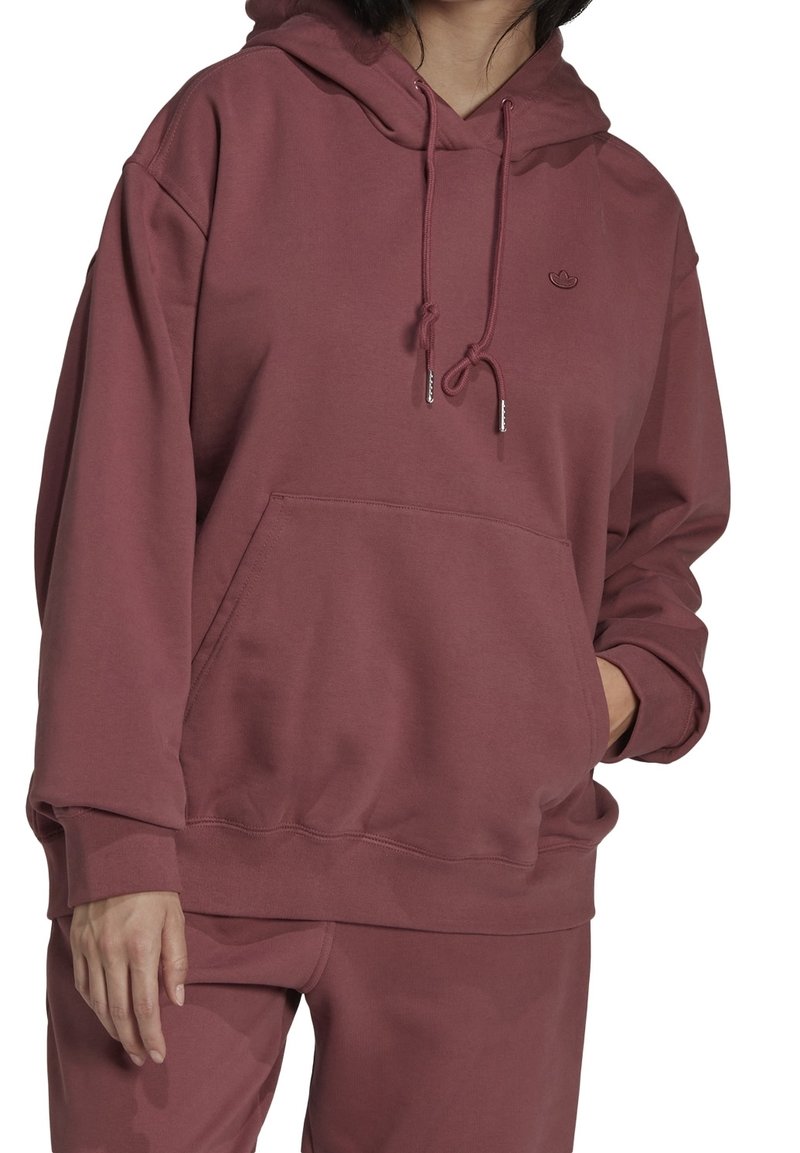 Felpa con cappuccio color bordeaux, dotata di tasca frontale, cordino regolabile e polsini a coste. Realizzata in materiale morbido, presenta un piccolo dettaglio con logo.
