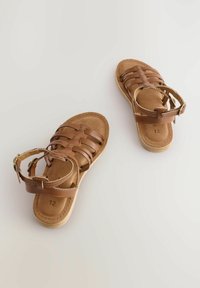 Bruine leren sandalen met meerdere bandjes, een gewatteerde binnenzool en een gesp-sluiting. Maat 12 aangegeven op de zool.