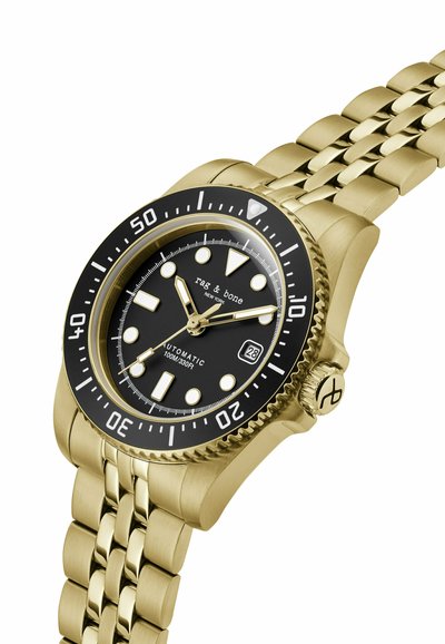 Montre-bracelet en métal doré avec cadran noir, index blancs, fenêtre date à 3 heures, lunette tournante et bracelet à maillons.