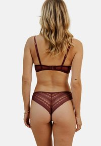 Ensemble de lingerie en dentelle bordeaux comprenant un soutien-gorge simple à bretelles réglables et un slip assorti à motif complexe avec un bord en feston.