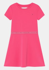 Różowa bawełniana sukienka z krótkimi rękawami, okrągłym dekoltem i rozkloszowanym dołem. Posiada kontrastujący biały pasek z logo, dodający wyrazu.