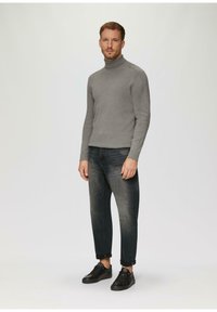 Grijze turtleneck trui, geribbelde textuur, gecombineerd met donkere spijkerbroek en zwarte sneakers. De trui heeft een aansluitend ontwerp en hoge kraag.