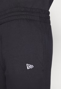 Pantaloni della tuta neri realizzati in una miscela di cotone, con vita a costine e un piccolo logo bianco sul lato sinistro.