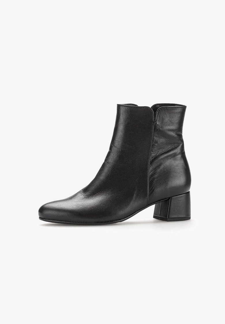 Bottine en cuir noir avec un bout rond et un talon mi-bloc. Présente une texture lisse et un design à coutures latérales.
