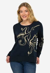 Sweatshirt bleu marine en tissu doux, arborant un design de pieuvre crème avec des accents dégoulinants sur le devant et les manches.