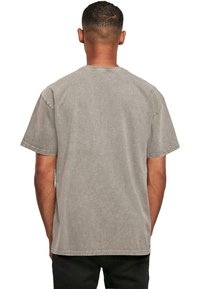 Gray cotton t-shirt with a relaxed fit, short sleeves, and visible stitching detail. Smooth texture, crew neckline, and no graphics or patterns.