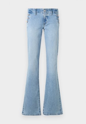 Lyseblå højtaljede jeans i denim med udvidede ben og sølvfarvede knapper langs sidelommerne på en hvid baggrund.