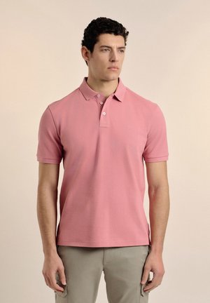 Camisa polo de manga corta en color rosa, confeccionada en tejido de algodón texturizado, con un cuello de dos botones y un pequeño logo en el pecho.