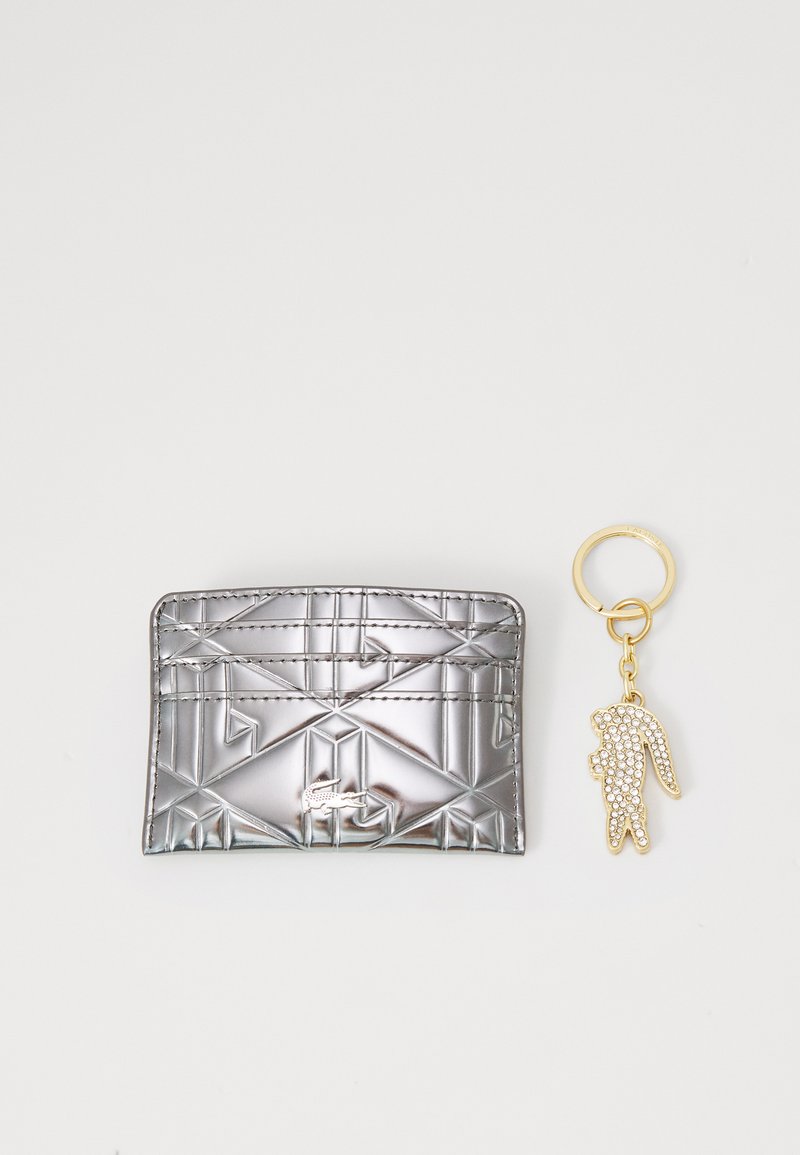 Porta کارت in argento metallico con motivo geometrico, featuring un portachiavi a forma di coniglio dorato decorato con strass trasparenti.