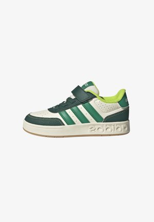 Zapatillas verdes y blancas con una parte superior de cuero y malla, que presentan tres rayas verdes, una correa de velcro y una suela de goma texturizada.