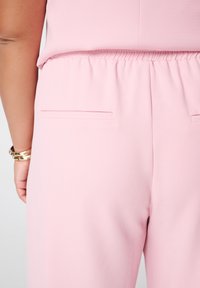 Lichtroze broek met een elastische tailleband, een gladde textuur en twee achterzakken met een strak design.
