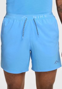 Helle blaue Sportshorts mit einem elastischen Bund, schwarzem Kordelzug und Logodetail. Der Stoff ist glatt und hat eine figurbetonte Passform.