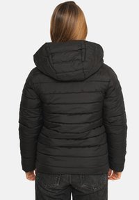 Veste matelassée noire isolée avec capuche, présentant un design matelassé, des coutures robustes et des poignets élastiques. Vue de dos montrant l'épaisseur et la chaleur.