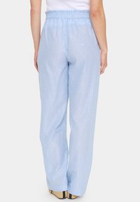 Light blue striped trousers with an elastic waistband, featuring a shiny finish and a relaxed wide-leg cut. Suitable for casual wear.