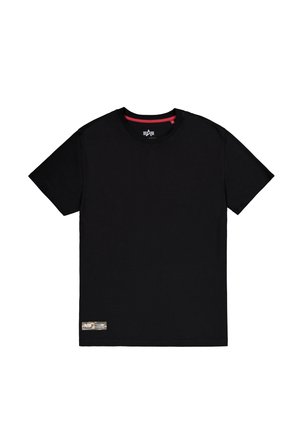 T-shirt noir avec un col rond, des manches courtes et une étiquette texturée en bas à gauche présentant une image en couleur. Matière en coton.
