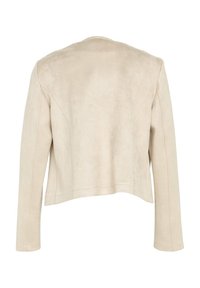 Veste en suède synthétique beige avec une coupe courte, des manches longues et des détails de coutures visibles, présentant un col rond et sans fermetures.