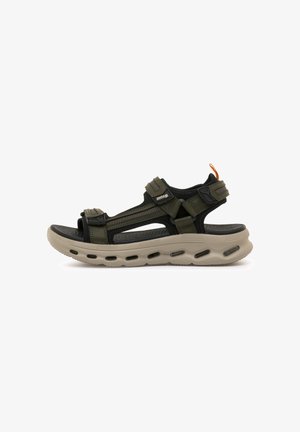 Zwarte en olijfgroene sandalen met verstelbare riemen, een gestructureerde zool en een lichtgewicht beige tussenzool met ventilatiegaatjes.