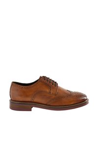 Chaussure habillée en cuir marron de style brogue avec perforations en aile d'oiseau, fermeture à lacets et talon empilé, sur fond blanc.