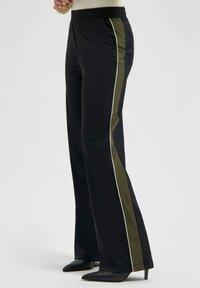Zwarte broek met een wijde pasvorm, met een groene zijstreep en witte piping. Gemaakt van gladde stof, met een elastische tailleband.
