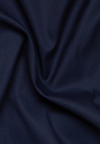 Diep marineblauwe stof met een gladde, matte textuur. Heeft subtiele plooien die flexibiliteit en hang geven. Geschikt voor verschillende textieltoepassingen.