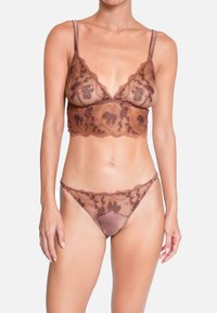 Soutien-gorge en dentelle marron à broderie florale, string transparent assorti. Les deux possèdent des bretelles réglables et une finition satinée douce.