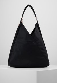 Black nylon bag with a distinctive triangular shape, featuring a sleek design and a textured handle, accented by rose gold hardware.