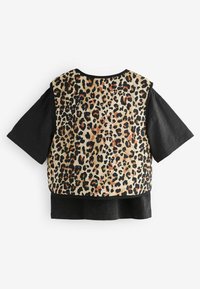 Camiseta de manga corta con un cuerpo de tela negra y un panel trasero acolchado de estampado de leopardo en beige, naranja y negro.