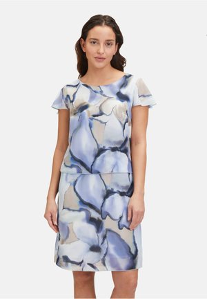 Robe à manches courtes présentant un motif floral bleu clair et beige, avec une coupe décontractée et une texture de tissu lisse.