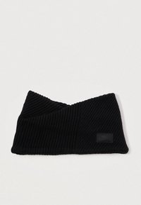 Bandă de headband tricotată neagră cu un model diagonal, cu o textură ribbată și un mic eticheta cu logo negru. Materialul pare călduros și elastic.