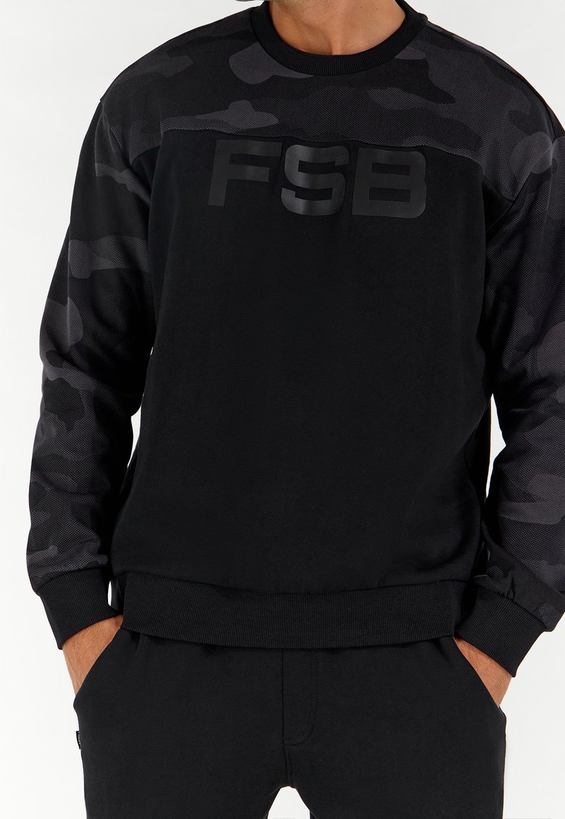 Czarna bluza z długim rękawem, z rękawami w wzór kamuflażu, teksturowany materiał i wypukłe logo "FSB" na piersi. Ściągacze na mankietach i u dołu.