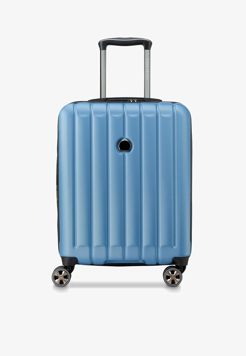 Maleta de mano de concha dura en azul claro con diseño acanalado vertical, acentos en negro, un mango telescópico y cuatro ruedas giratorias.