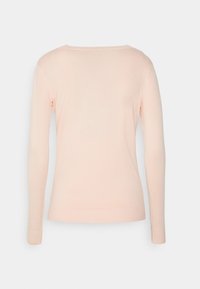 Jasnoróżowy sweter z długim rękawem, okrągłym dekoltem, prążkowanym wykończeniem u dołu i na mankietach, o gładkiej fakturze, bez widocznych wzorów czy akcentów.