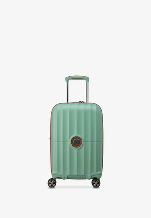 Maleta rígida en verde menta con ranuras texturizadas, acentos marrones, un logo circular, mango retráctil y cuatro ruedas.