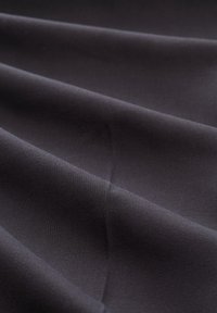 Dark, smooth fabric draped in folds, showcasing a consistent texture and deep color with subtle sheen. No visible patterns or hardware.