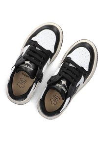 Zwart-witte sneakers met een glad leren bovenwerk, vetersluiting, geperforeerde neus en een zachte beige binnenzool. Accenten zijn onder andere de branding op de tong.