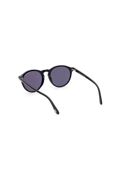 Occhiali da sole rotondi neri con lenti scure, montatura in plastica elegante, design minimalista, aste sottili e dettagli dorati sulla tempia.