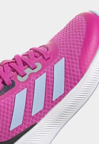 Scarpa da ginnastica rosa con tomaia in rete testurizzata, strisce grigie e azzurre, e suola bianca imbottita, dotata di lacci e occhielli coordinati.