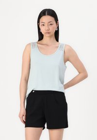 Débardeur bleu clair sans manches avec des détails en dentelle sur les épaules, associé à un short noir cintré. Tissu lisse, coupe décontractée.