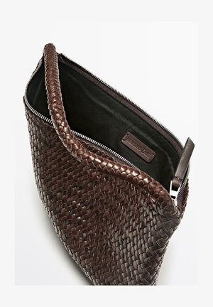 Sac en cuir marron tressé avec fermeture éclair, présentant un extérieur texturé et une doublure intérieure noire lisse.