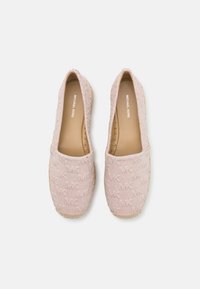 Zapatos de slip-on de color rosa claro, hechos de tela texturizada con suela de yute trenzado y detalles bordados. Cuentan con un acolchado interior para mayor comodidad.