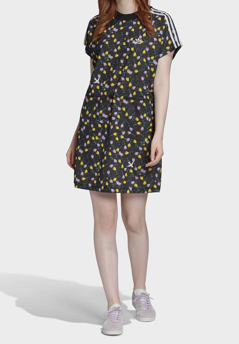 Černé šaty s květinovým vzorem a krátkým rukávem, zdobené žlutými a fialovými květinami. Obsahují bílé postranní pruhy a volný střih.