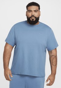 Light blue short-sleeve t-shirt made of soft fabric, featuring a round neckline and a small logo on the chest. Smooth texture with relaxed fit.