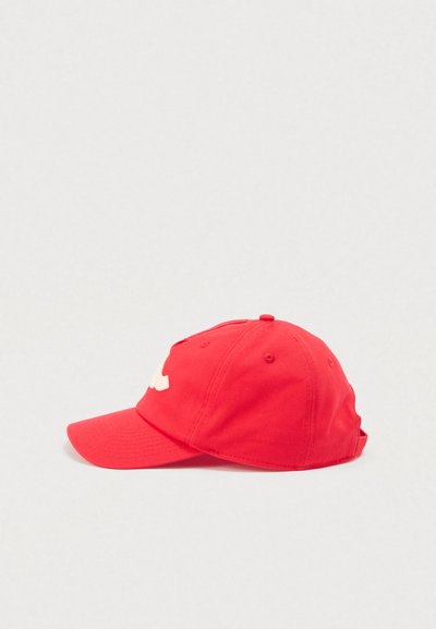 Κόκκινο καπέλο μπέιζμπολ με καμπύλη κορυφή, κατασκευασμένο από ύφασμα. Διαθέτει λευκό λογότυπο μπροστά, έξι οπές για αερισμό και ρυθμιζόμενο λουράκι.