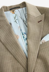 Beige gestreifter Blazer mit einer blauen floral gemusterten Fütterung, ausgestattet mit Revers und einer Einschubtasche.
