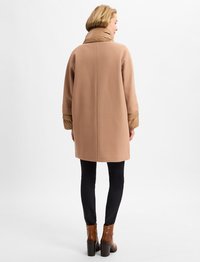 Beige ullblandad kappa med vadderad brun krage och manschetter, medellång design, har rak skärning och enkel detalj på bakseam.
