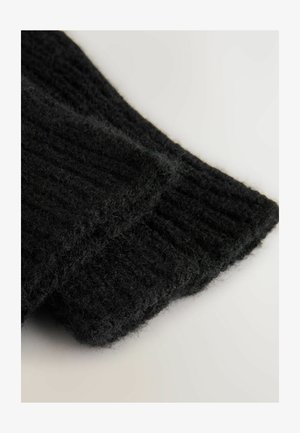 Sort strikket sweater med ribbet tekstur. Stoffet ser blødt og fuzzy ud, med et nærbillede af manchetten, der viser detaljerne.